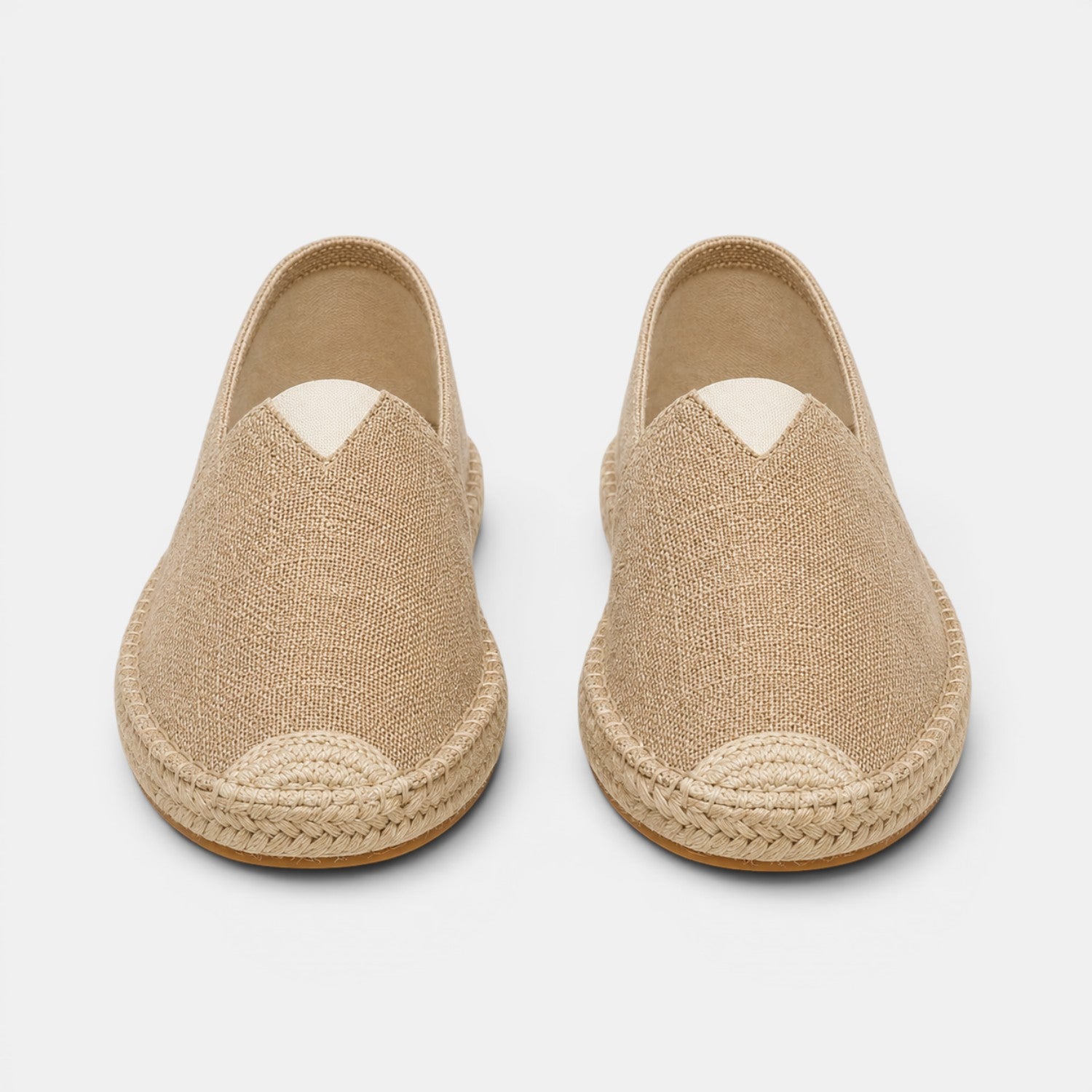 Pair of beige espadrilles on a light gray background