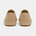Pair of beige espadrilles on a light gray background