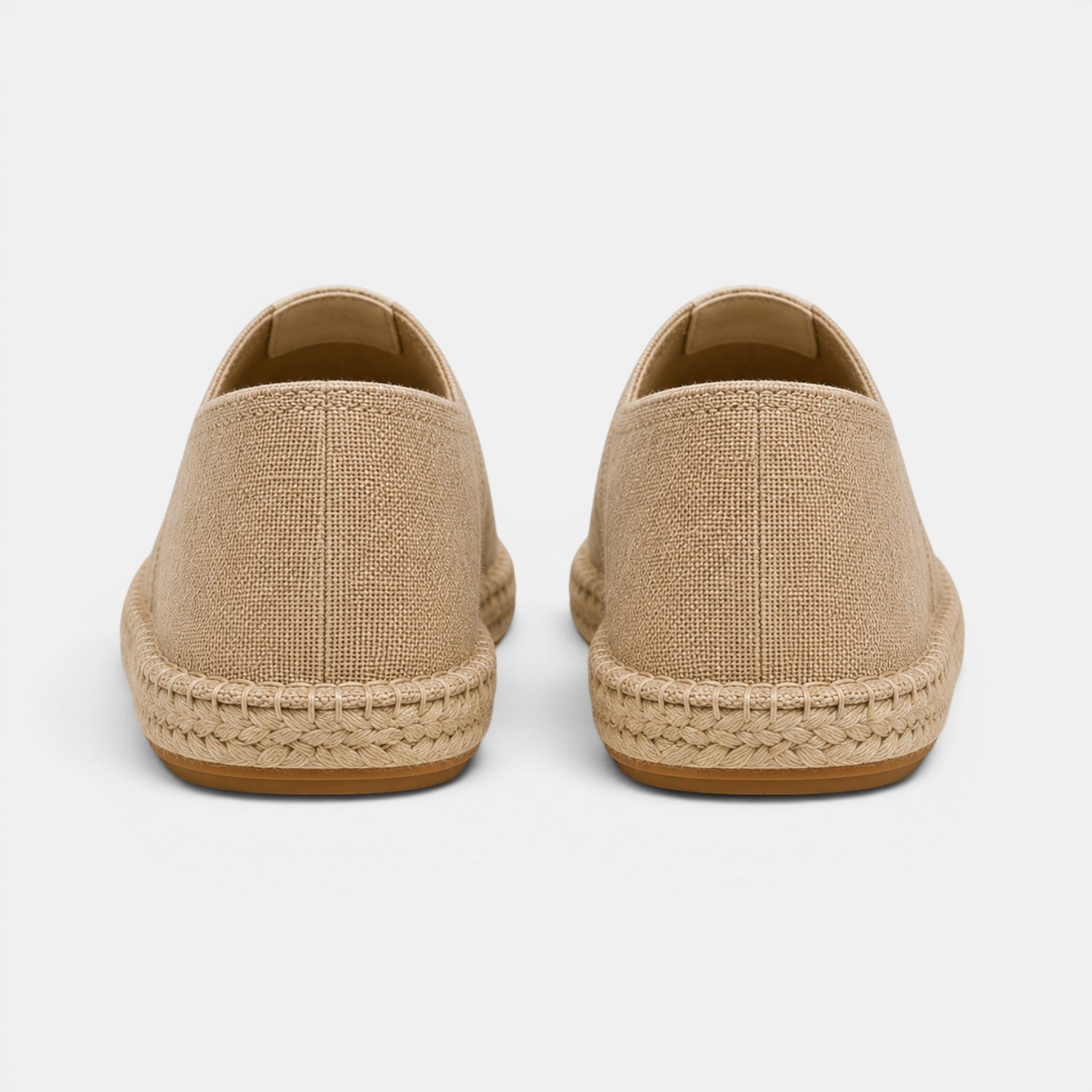 Pair of beige espadrilles on a light gray background