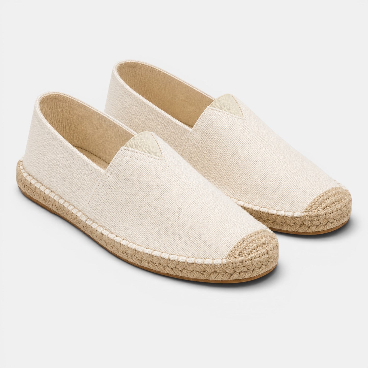 Pair of beige espadrilles on a white background