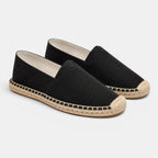Pair of black espadrilles with jute sole on a white background