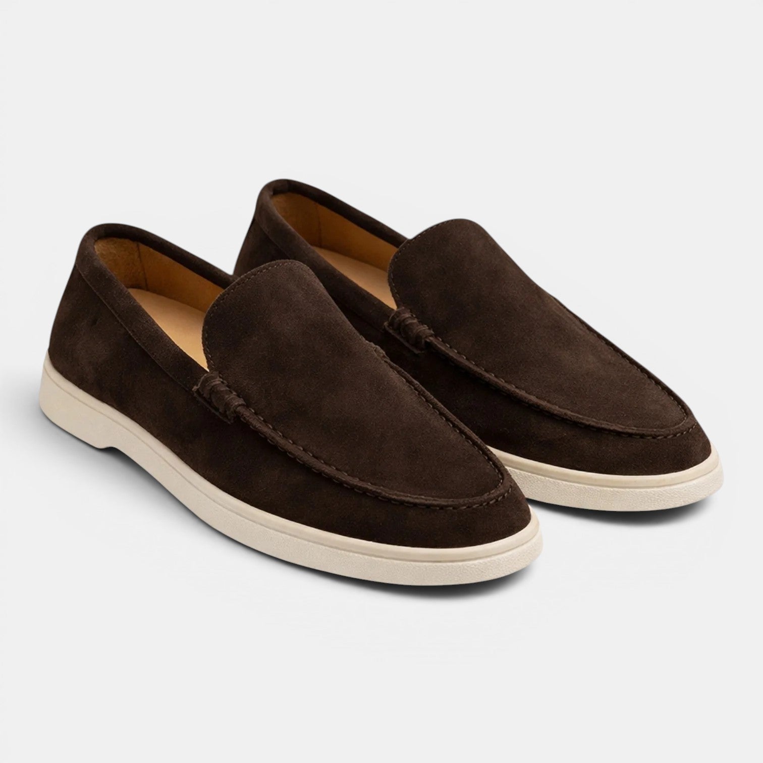 Pair of brown suede loafers on a light gray background
