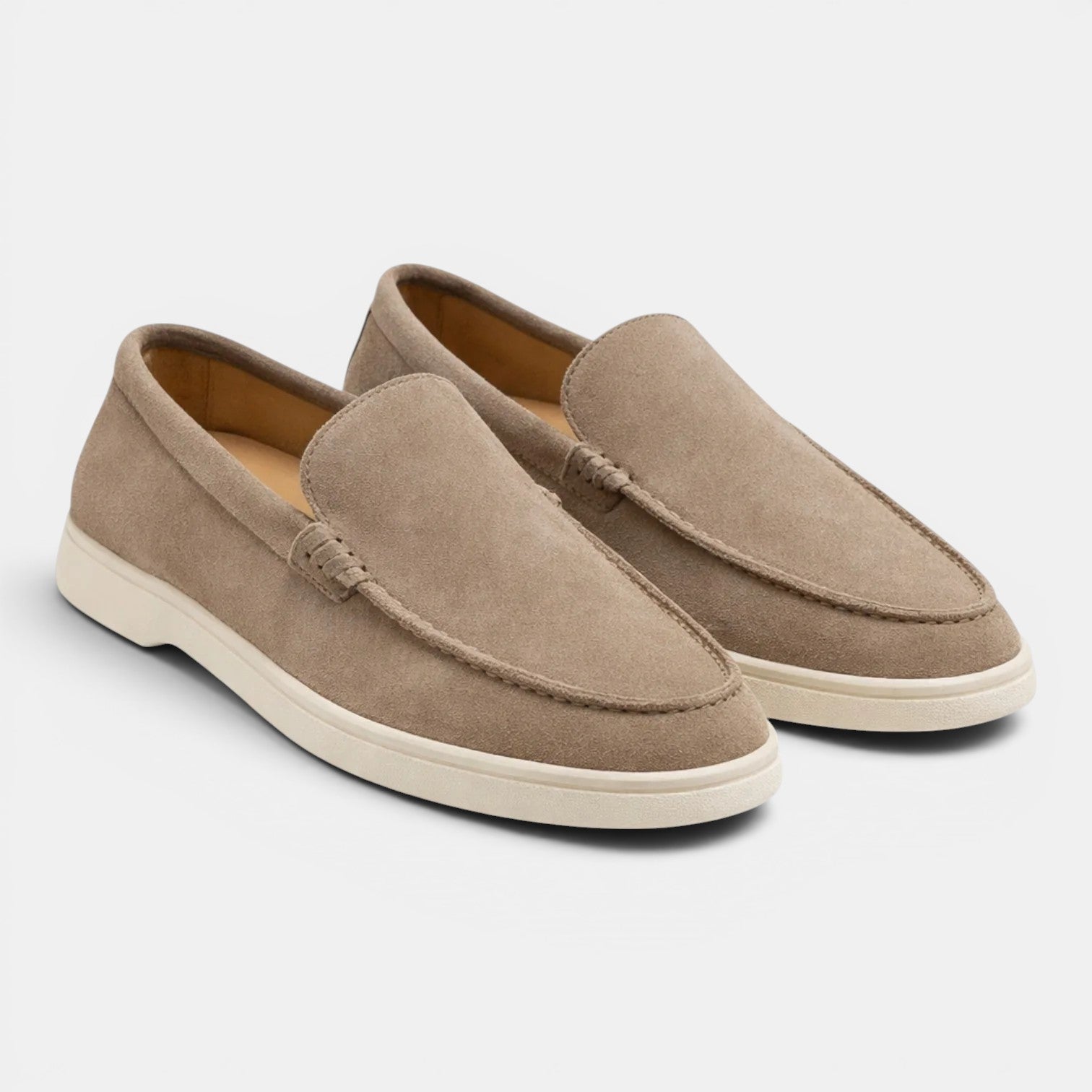 Pair of beige loafers on a light gray background