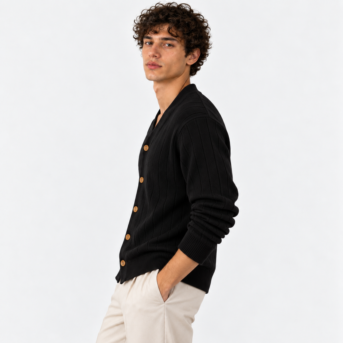 Side view of a man wearing a black ribbed knit cardigan with white trousers