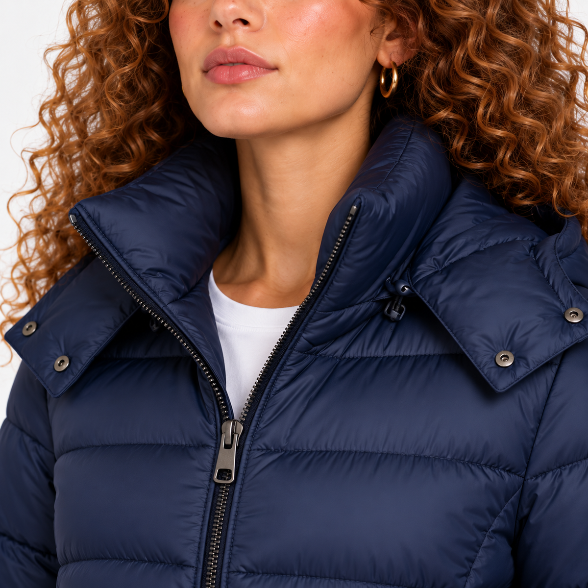 Close-up of women's navy blue puffer coat with high collar and front zipper closure