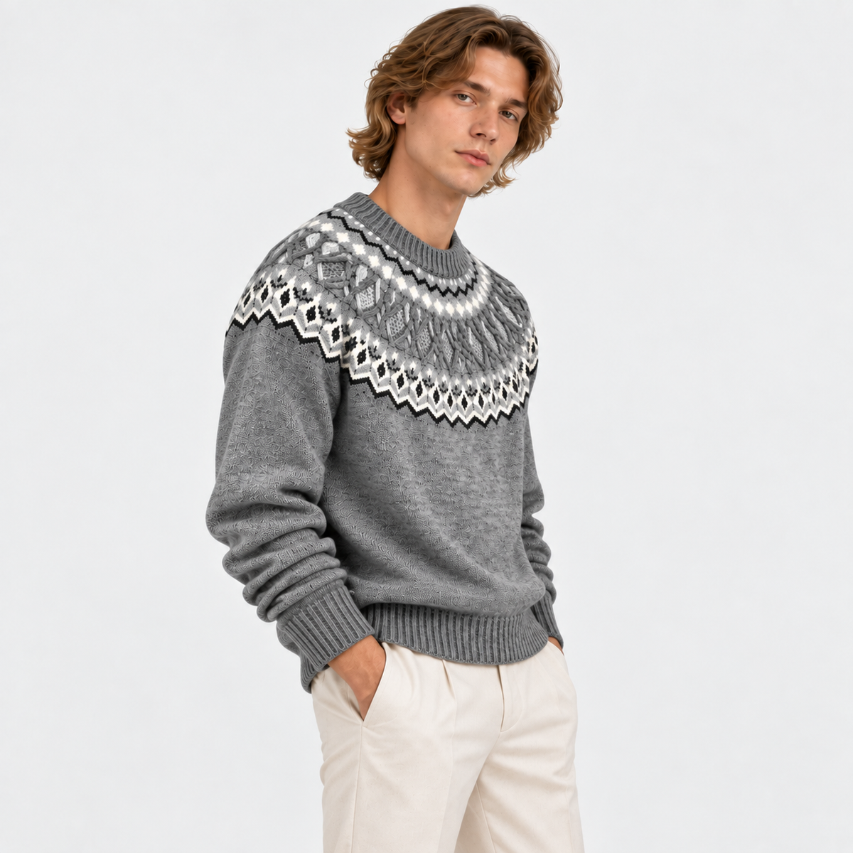 Side view of a man wearing a gray Fair Isle knit sweater with white trousers