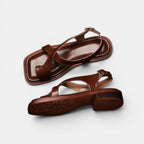 Pair of brown sandals on a light gray background