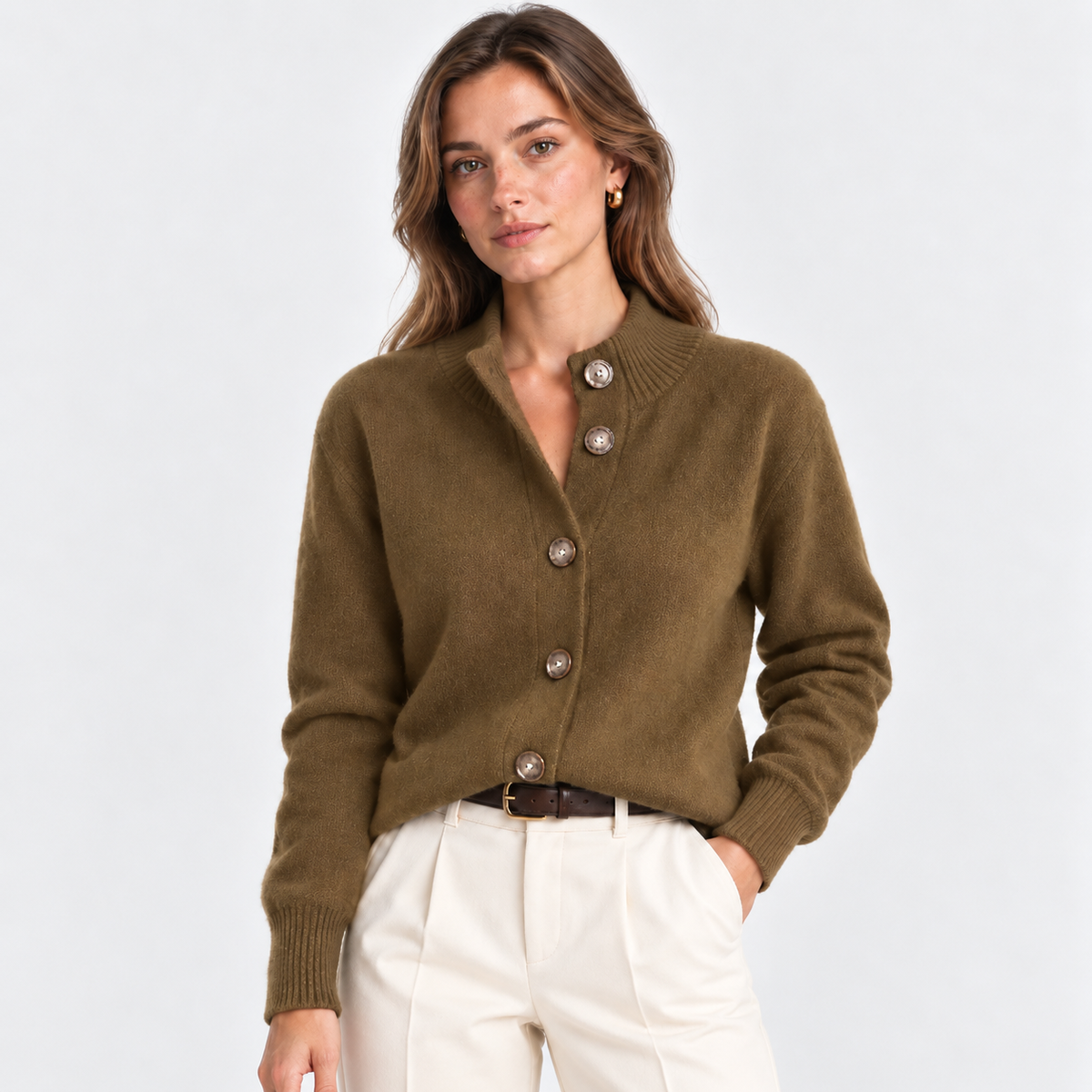 A woman modeling brown button-up cardigan sweater with ribbed collar, cuffs, and hem, paired with off-white trousers, against a light gray studio background.