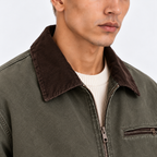 Close-up of men's olive green jacket with brown corduroy collar and front zipper