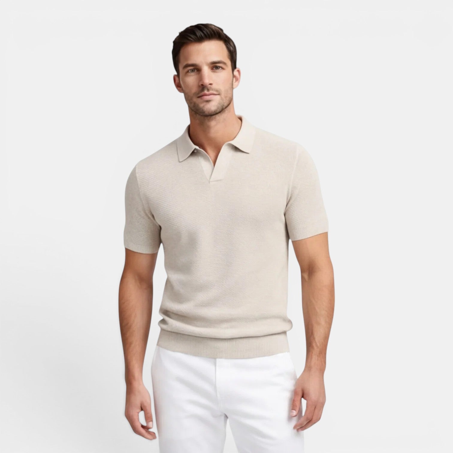 Man wearing a beige polo shirt and white pants on a light gray background