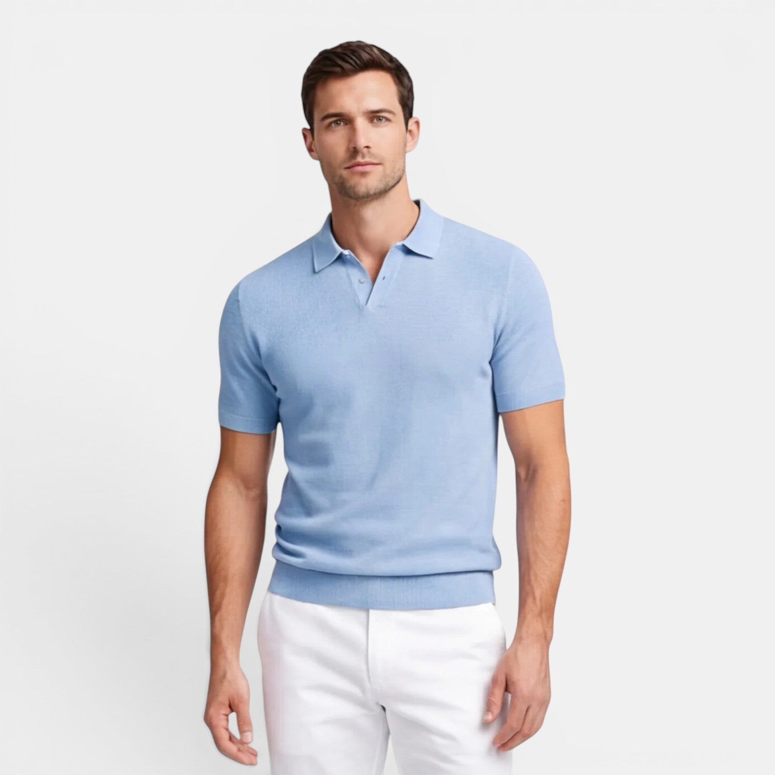 Man wearing a light blue polo shirt and white pants on a plain background