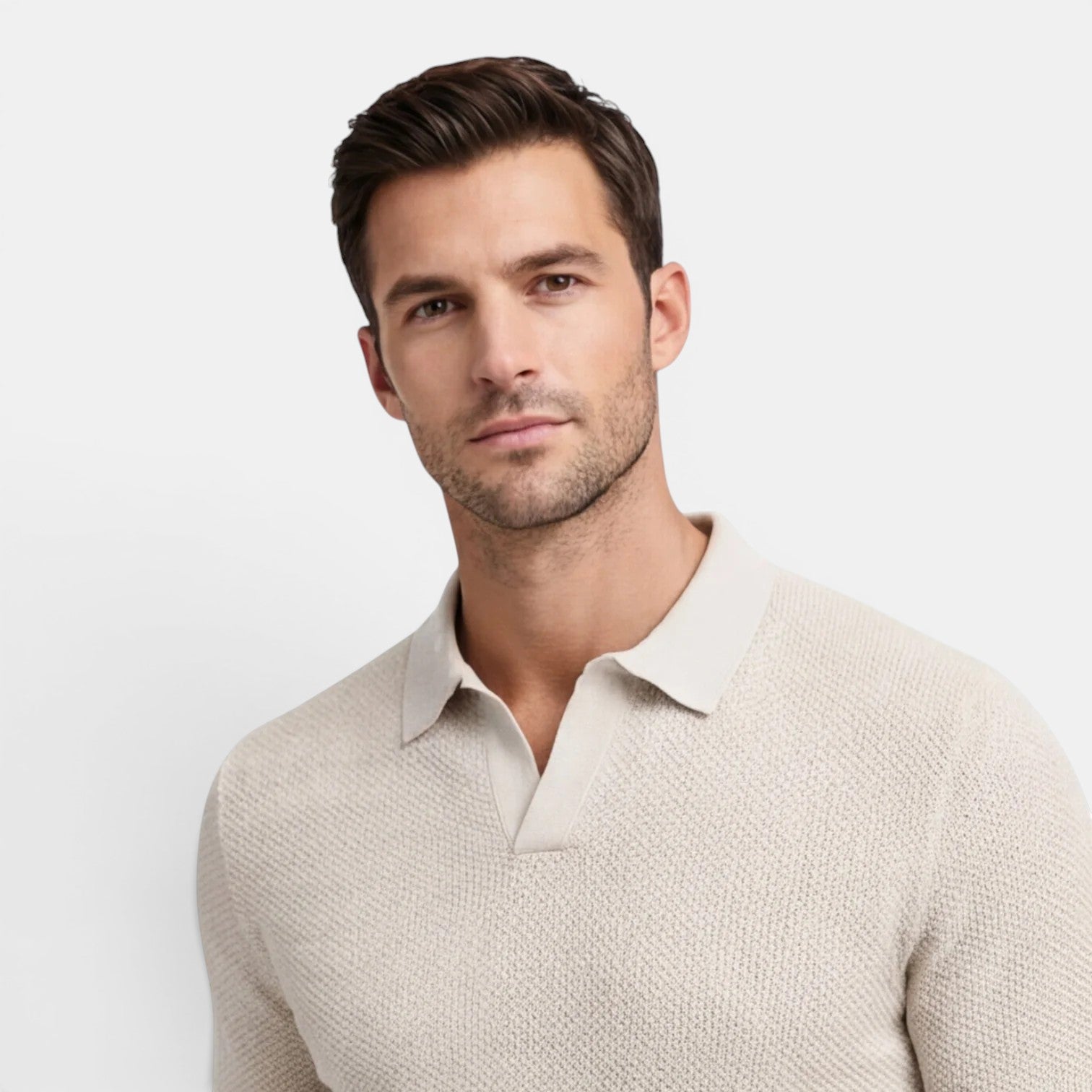 Man wearing a beige sweater against a white background