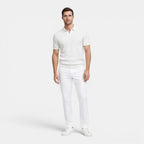 Man wearing a white polo shirt and pants on a white background