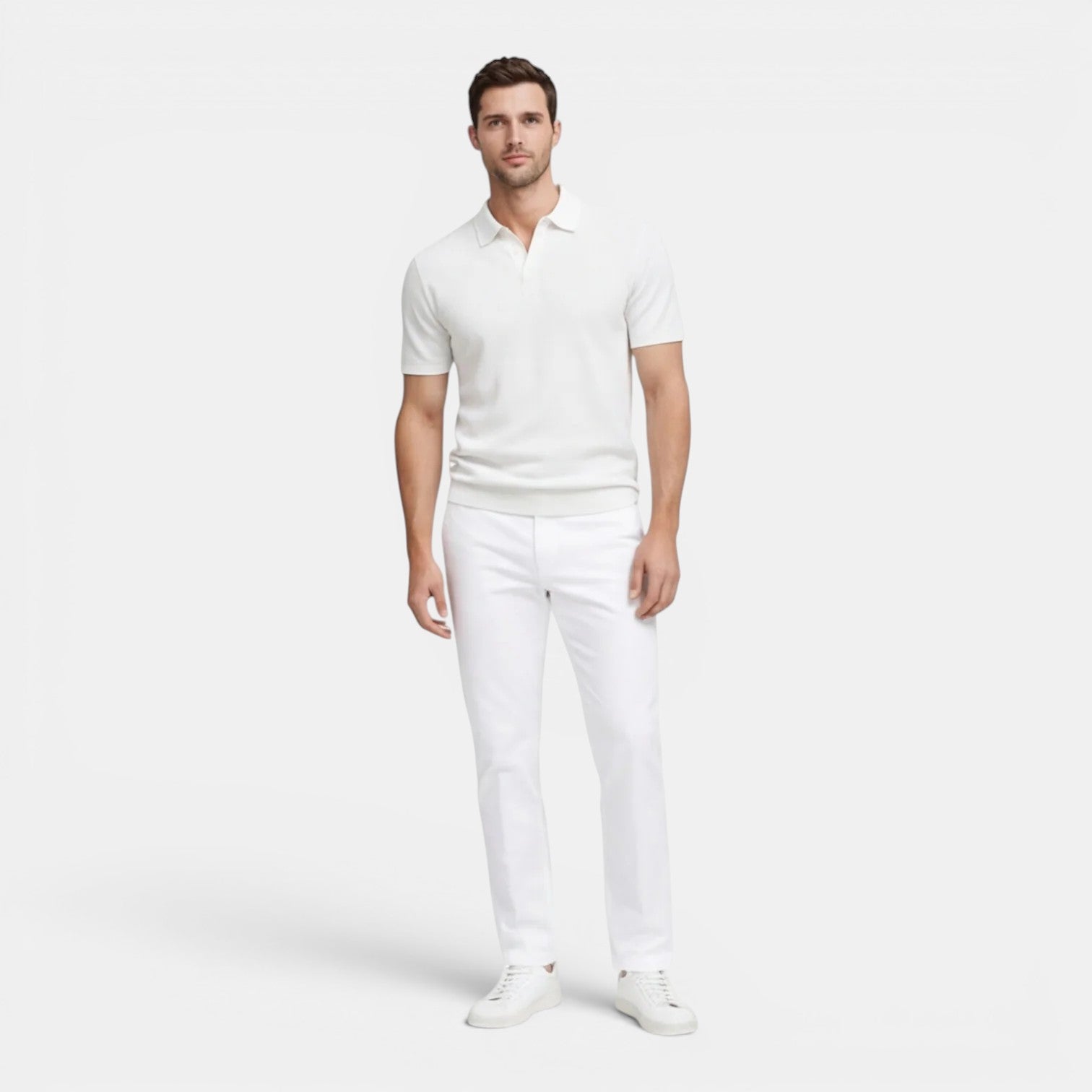 Man wearing a white polo shirt and pants on a white background