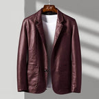 Brown leather jacket on a hanger against a neutral background