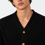 Close-up of men's black ribbed cardigan with V-neckline and wooden buttons