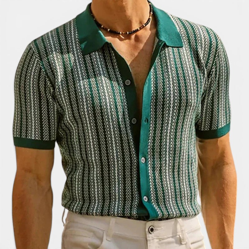 Man wearing a patterned shirt with green collar and trim on a white background