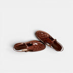 Pair of brown sandals on a light gray background