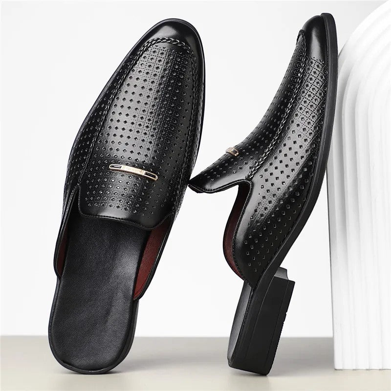 Black leather loafers with a textured surface on a white background
