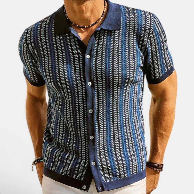 Man wearing a blue and black patterned shirt on a white background
