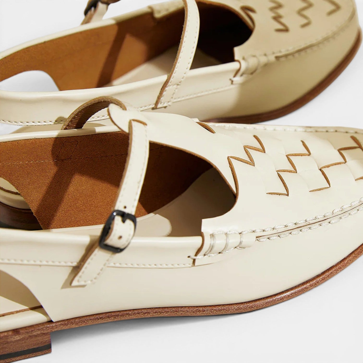 Beige sandals with brown soles on a white background