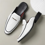 White loafers with black accents on a light gray background