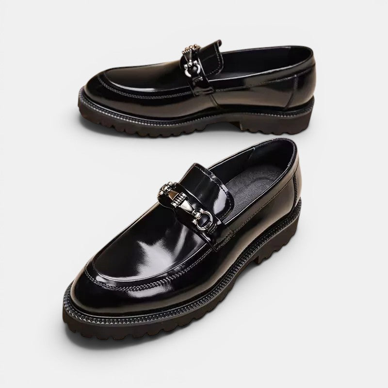 Pair of black glossy loafers on a white background