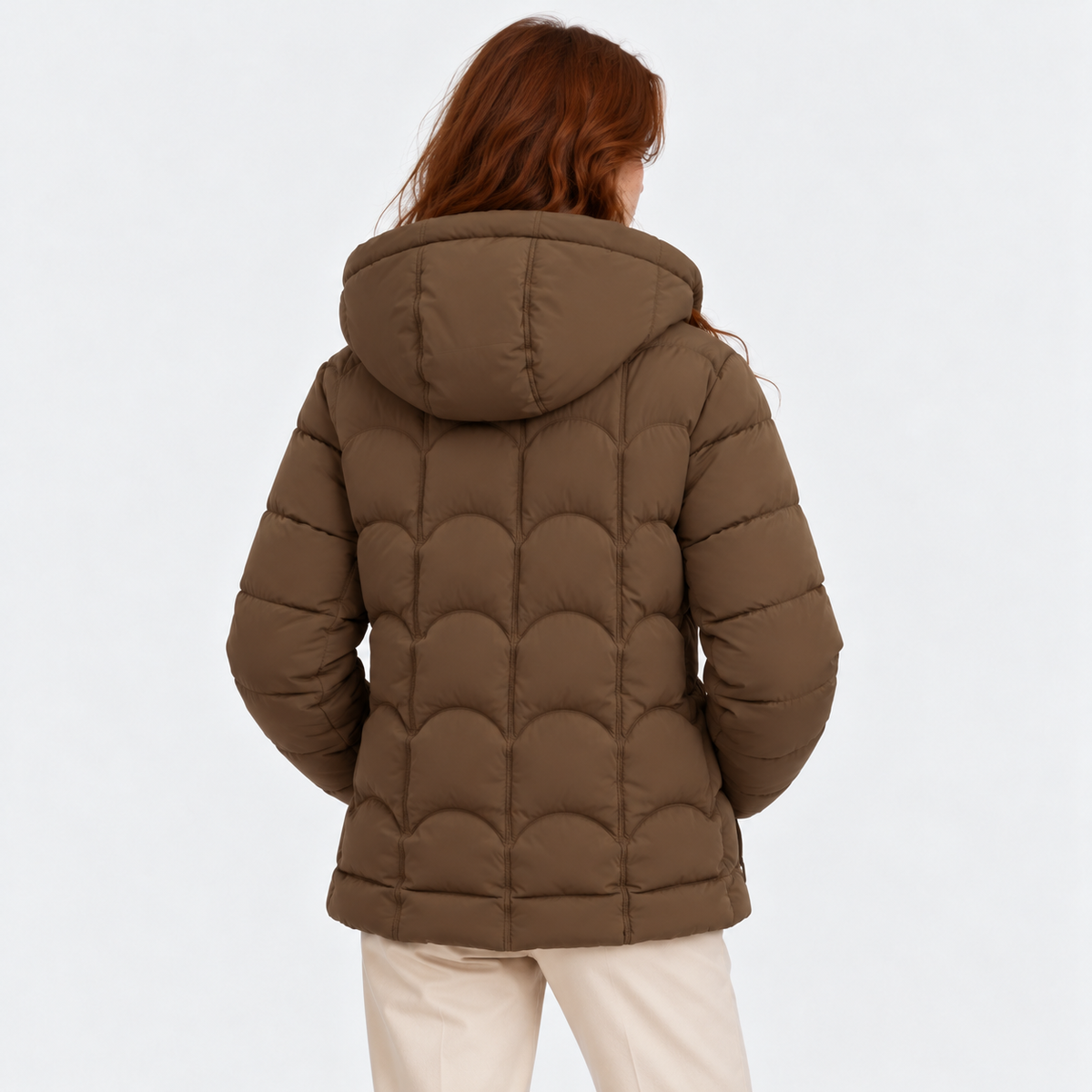 Back view of a woman wearing a taupe brown quilted puffer jacket with hood