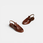 Pair of brown sandals on a light gray background