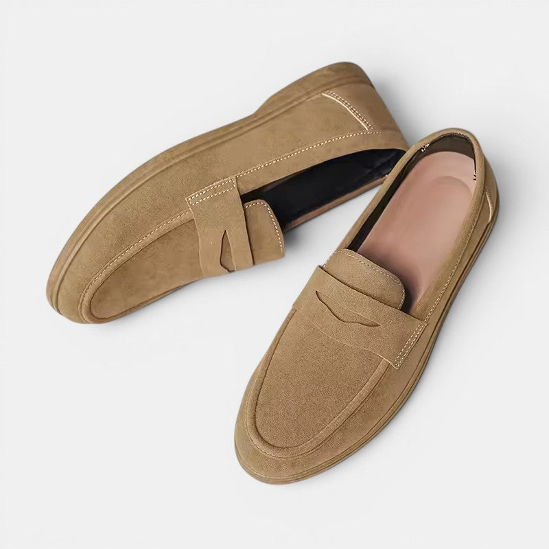 Pair of tan loafers on a light gray background