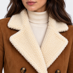 Close-up of women's brown coat with cream faux fur lapels and double-breasted buttons