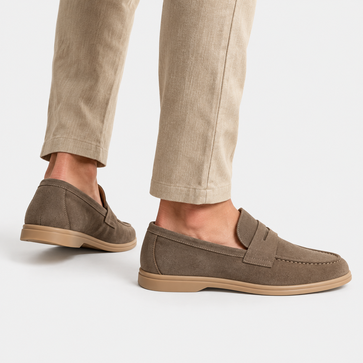 Side view of men's brown suede loafers paired with beige trousers