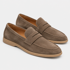 Men's brown suede loafers with penny strap detail and flat rubber soles