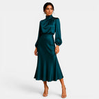 Woman wearing a teal dress on a white background