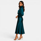 Woman wearing a teal dress on a white background