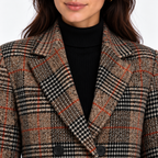 Close-up of women's brown plaid blazer with notched lapels and double-breasted buttons