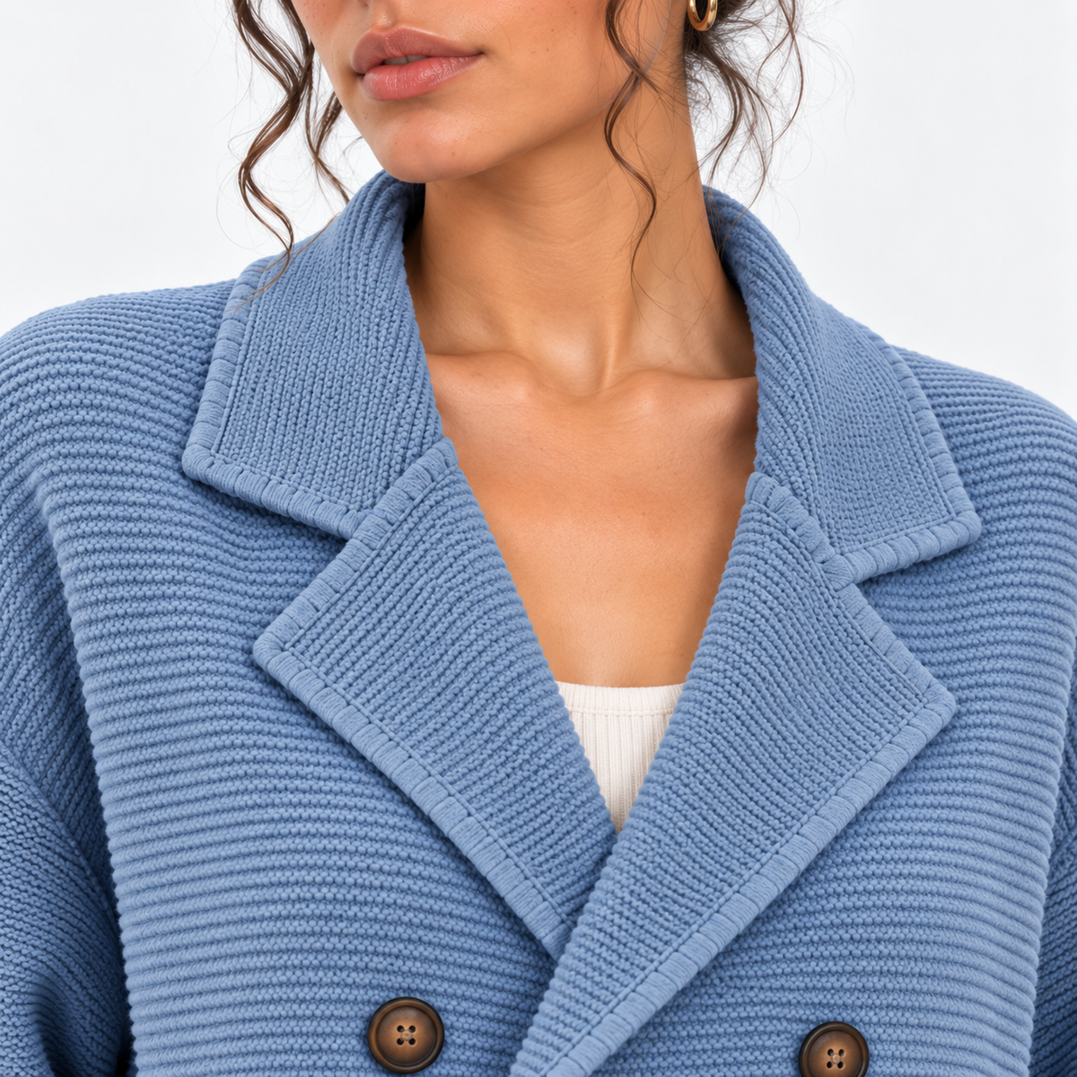 Close-up of women's light blue knit blazer with notched lapels and double-breasted buttons
