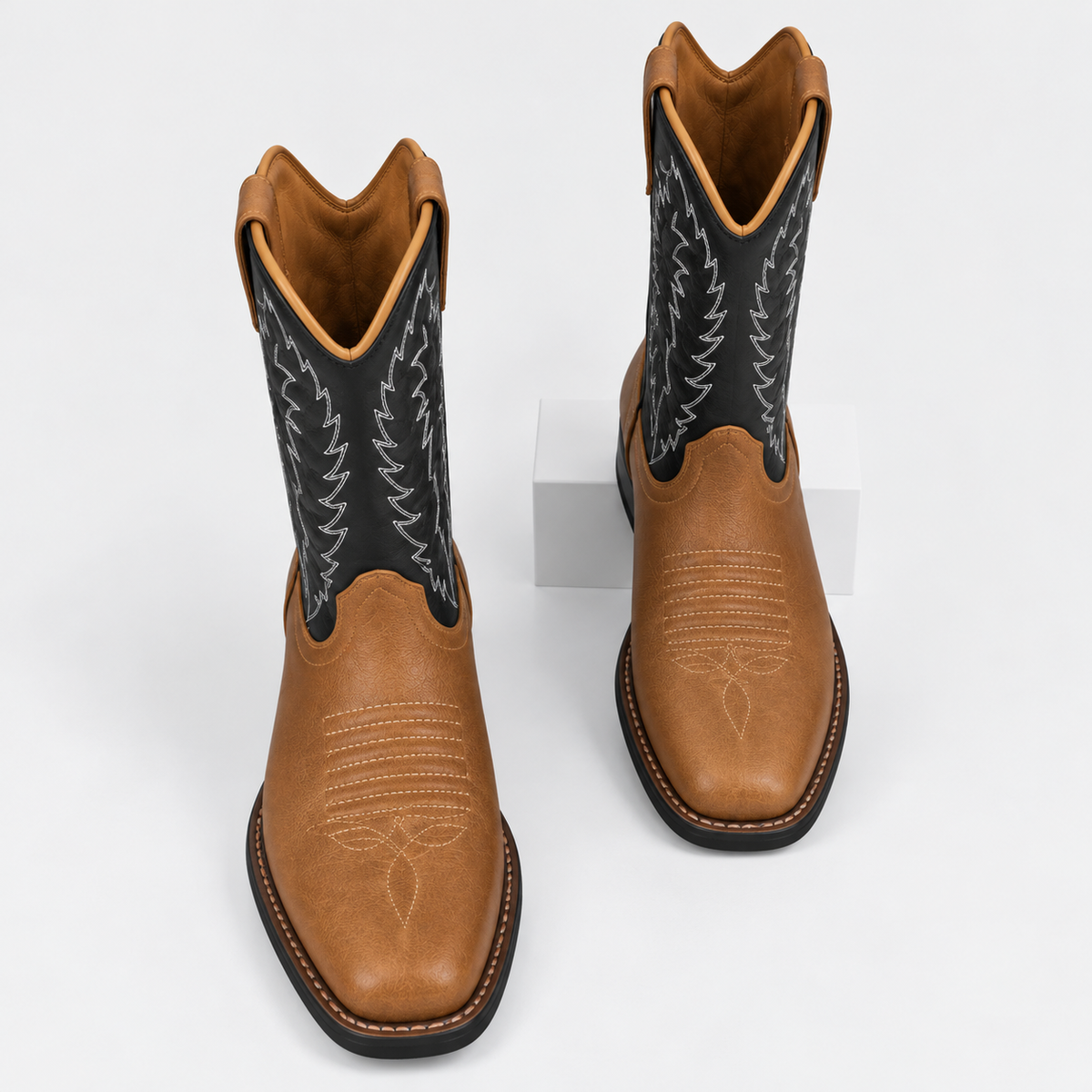 Women's tan western cowboy boots with black embroidered shafts and pointed toes