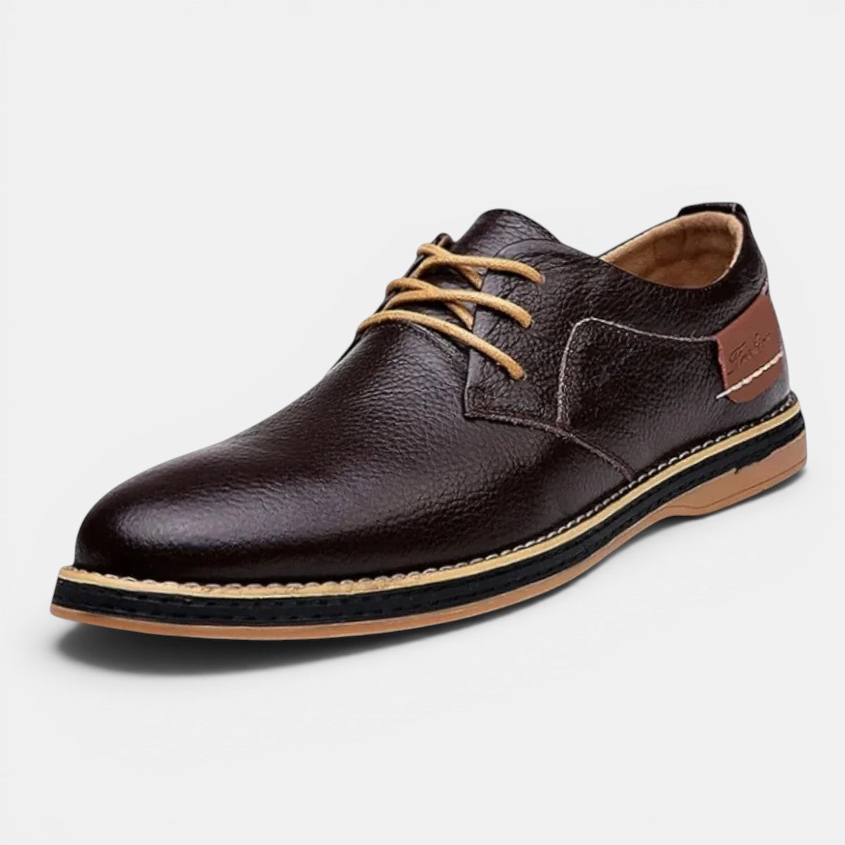 Brown leather shoe with a black sole on a light gray background