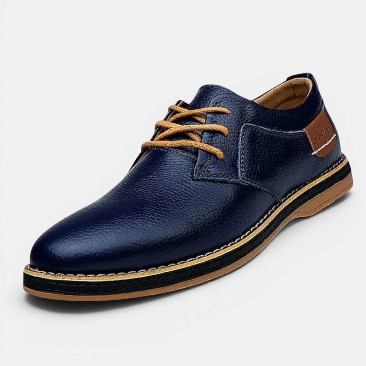 Navy leather shoe with brown laces and sole on a light gray background