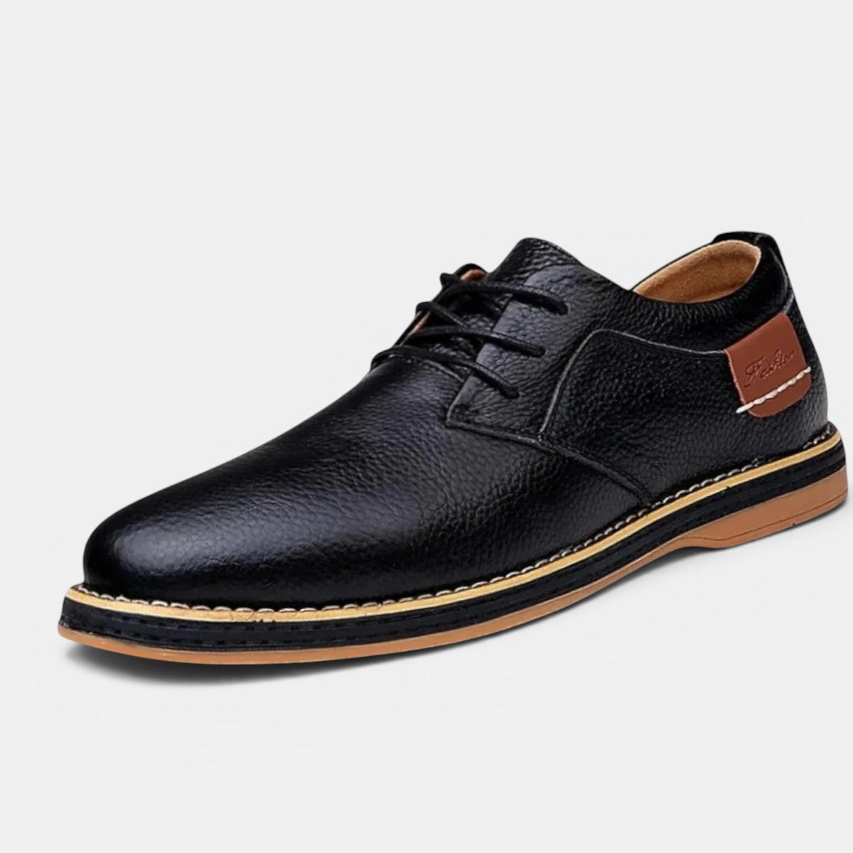 Black leather dress shoe with brown sole on a white background