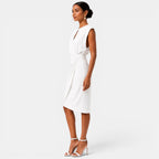 Woman wearing a white dress on a plain background