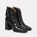 A pair of black leather ankle boots with a chunky block heel and square toe, shown on a light gray background.