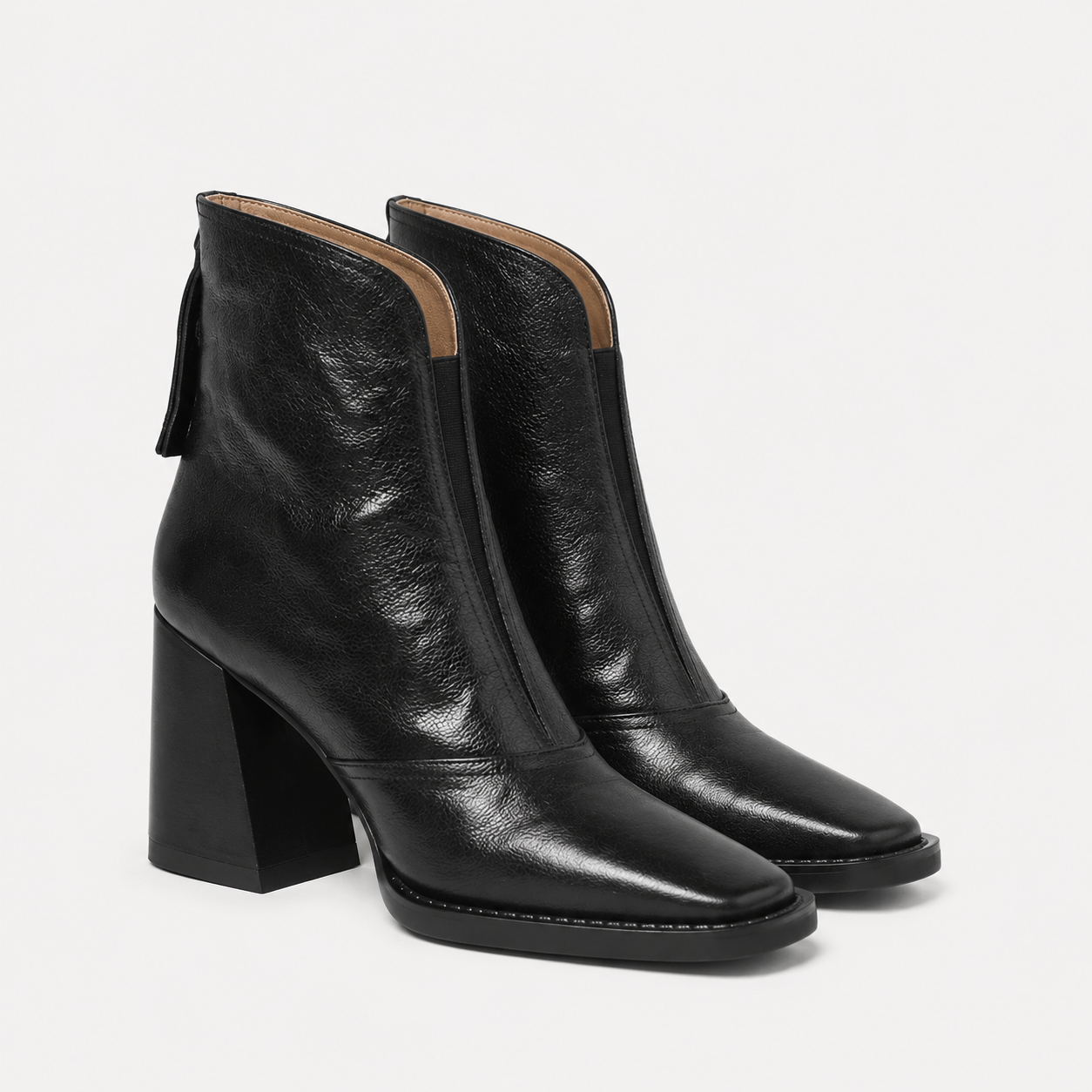 A pair of black leather ankle boots with a chunky block heel and square toe, shown on a light gray background.