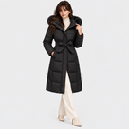 Women's black long puffer coat with faux fur hood trim, waist belt, and front pockets
