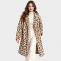 A woman modeling a mid-length leopard-print faux fur coat over a cream ribbed turtleneck and cream wide-leg trousers, shot against a solid light gray background.