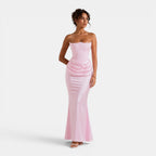 Woman wearing a strapless pink evening gown on a white background