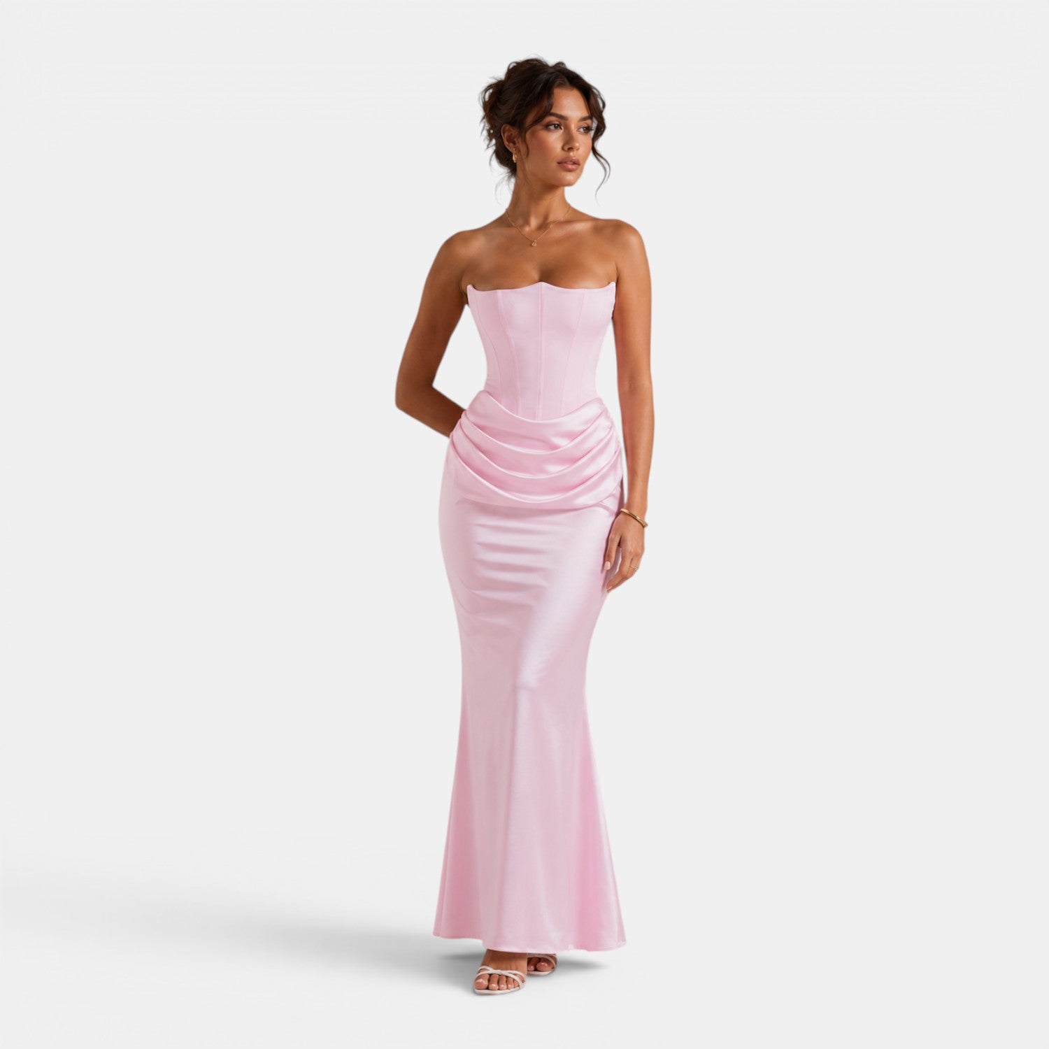 Woman wearing a strapless pink evening gown on a white background