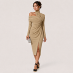 A woman models a beige off-the-shoulder long-sleeve midi dress with a ruched gathered waist and a front slit, paired with black wedge sandals and a small silver clutch, against a solid light beige background.
