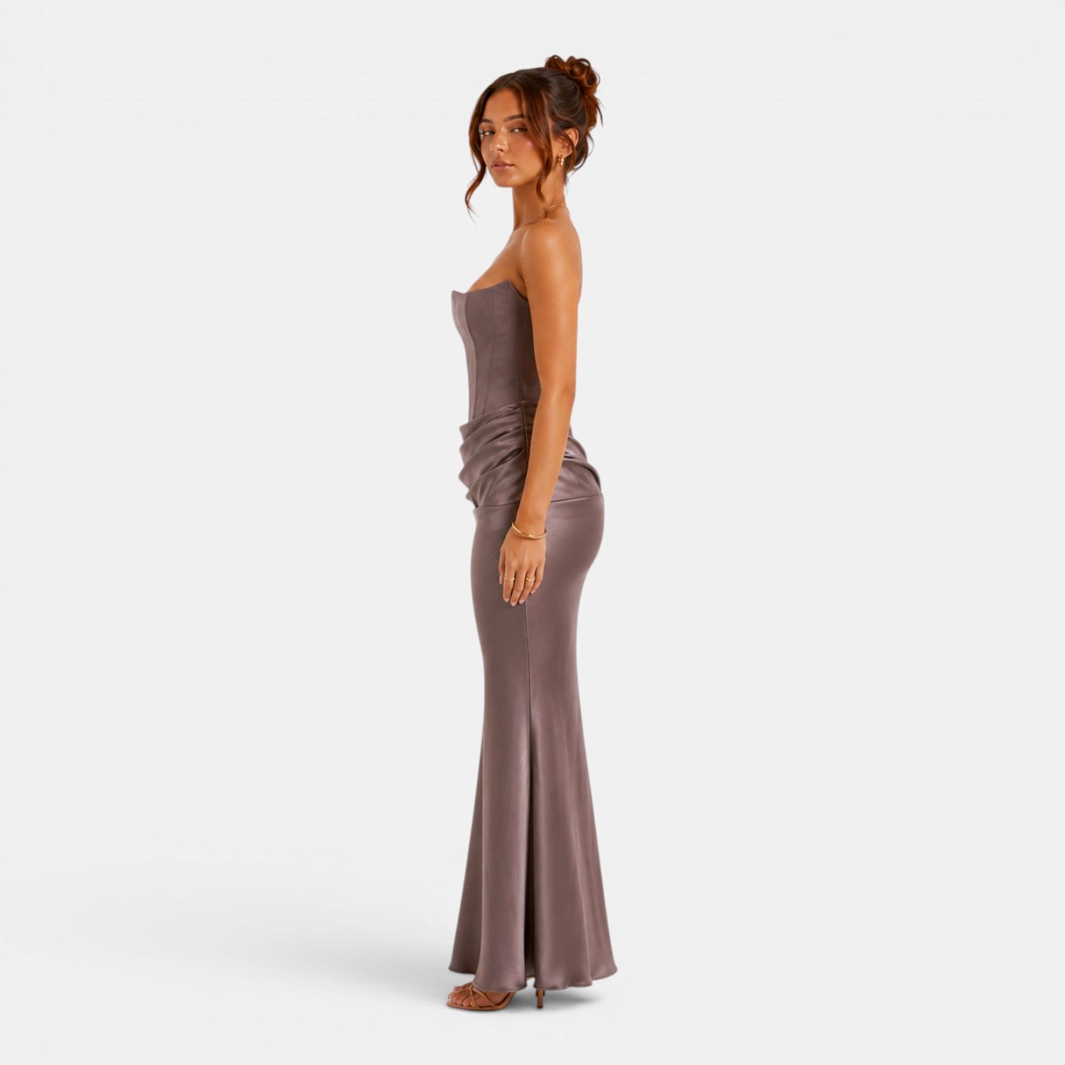 Woman wearing a strapless, floor-length dress on a white background